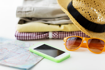 Image showing close up of summer clothes and travel map on table