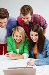 Image showing smiling students looking at laptop at school