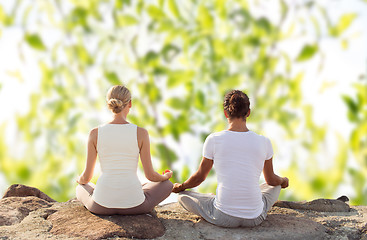 Image showing smiling couple making yoga exercises outdoors