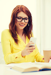 Image showing smiling student girl with smartphone at school