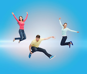 Image showing group of smiling teenagers jumping in air