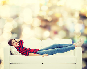 Image showing smiling teenage girl lying on sofa