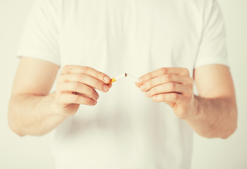 Image showing man breaking the cigarette with hands