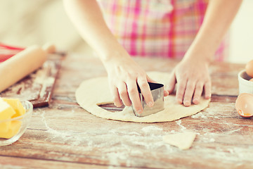 Image showing close up of hands making cookies from fresh dough