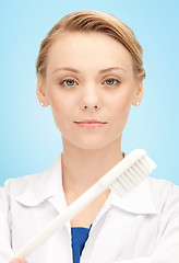 Image showing happy young female dentist with tooth brush