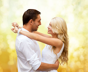 Image showing happy couple hugging over yellow lights background