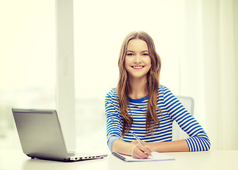 Image showing smiling teenage girl laptop computer and notebook