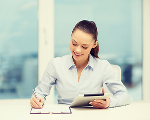 Image showing businesswoman with tablet pc and files in office