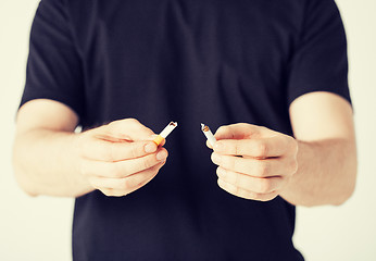 Image showing man breaking the cigarette with hands