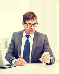 Image showing businessman working with laptop and smartphone