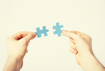 Image showing two hands trying to connect puzzle pieces