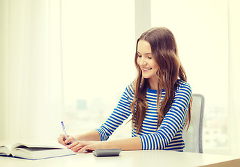 Image showing student girl with book, calculator and notebook