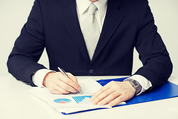 Image showing businessman working and signing papers