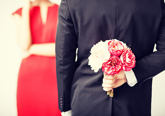 Image showing man hiding bouquet of flowers