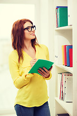 Image showing female student in eyeglasses with textbook