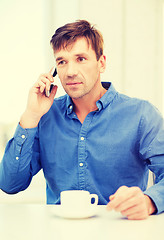 Image showing buisnessman with cell phone and cup of coffee