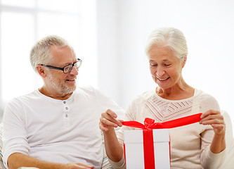 Image showing happy senior couple with gift box at home