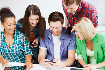 Image showing students looking into smartphone at school