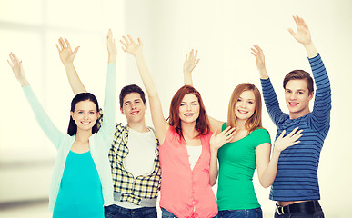 Image showing group of smiling students waving hands