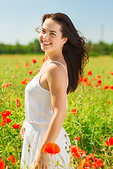 Image showing smiling young woman on poppy field