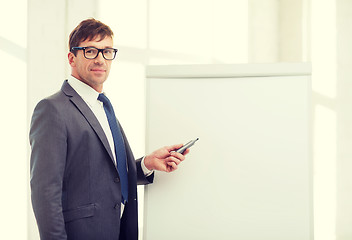 Image showing businessman pointing to flip board in office