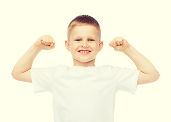 Image showing little boy in blank white t-shirt showing muscles