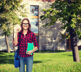 Image showing smiling female student with bag and notebooks