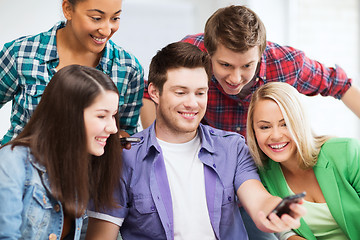 Image showing students looking into smartphone at school