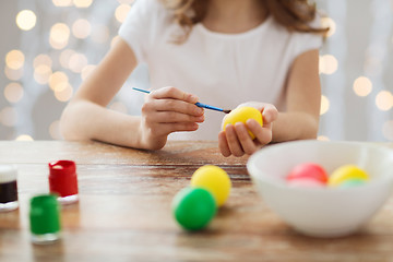 Image showing close up of girl with brush coloring easter eggs