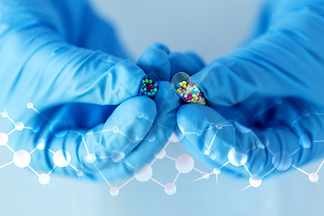 Image showing close up of scientist hands holding pill in lab