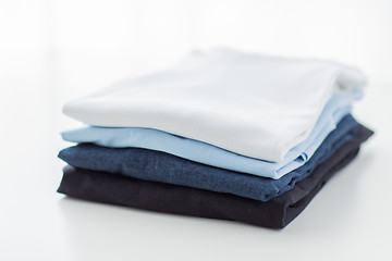 Image showing close up of ironed and folded t-shirts on table