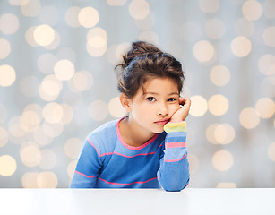 Image showing sad little girl over city background