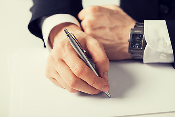 Image showing businessman writing something on the paper