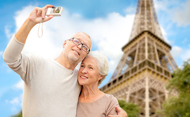 Image showing senior couple with camera over eiffel tower