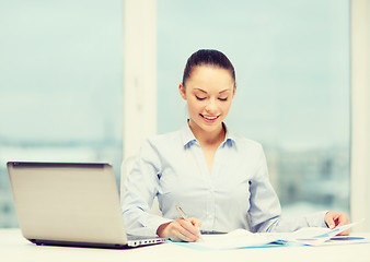 Image showing businesswoman with laptop and charts in office