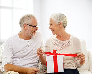 Image showing happy senior couple with gift box at home