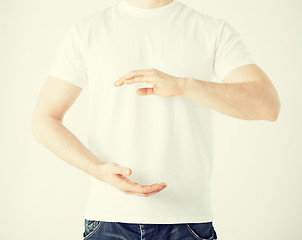 Image showing mans hands showing something