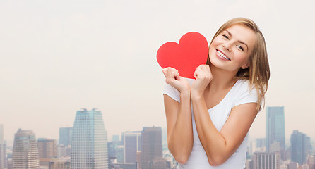 Image showing smiling woman in white t-shirt holding red heart