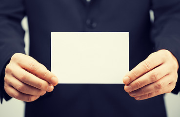 Image showing man in suit holding blank card