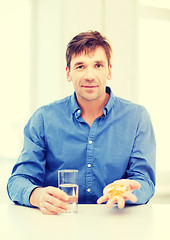 Image showing man at home showing lot of pills