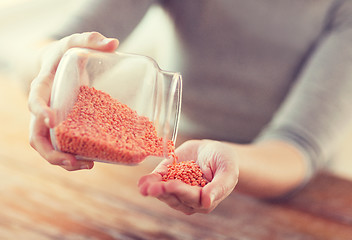 Image showing close up of female emptying jar with red lentils