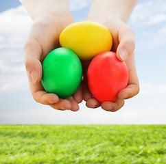 Image showing close up of kid hands holding colored eggs