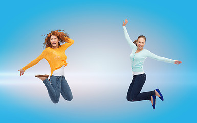 Image showing smiling young women jumping in air