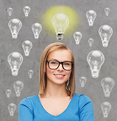 Image showing smiling young woman in eyeglasses having idea