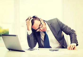 Image showing businessman with computer, papers and calculator