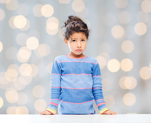 Image showing sad little girl over city background