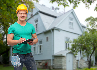 Image showing smiling manual worker in helmet with clipboard