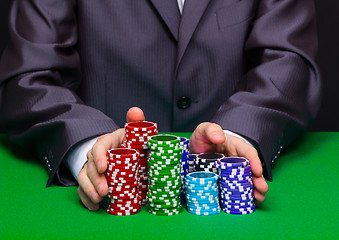 Image showing Man puts in the casino. Hand with chips