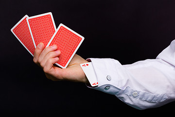 Image showing man's hand holding three cards and the ace in the hole