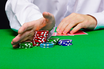 Image showing Man puts in the casino. Hand with chips